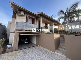 Foto da fachada de uma residência em Lajeado, Brasil, mostrando a área da garagem e o terraço.