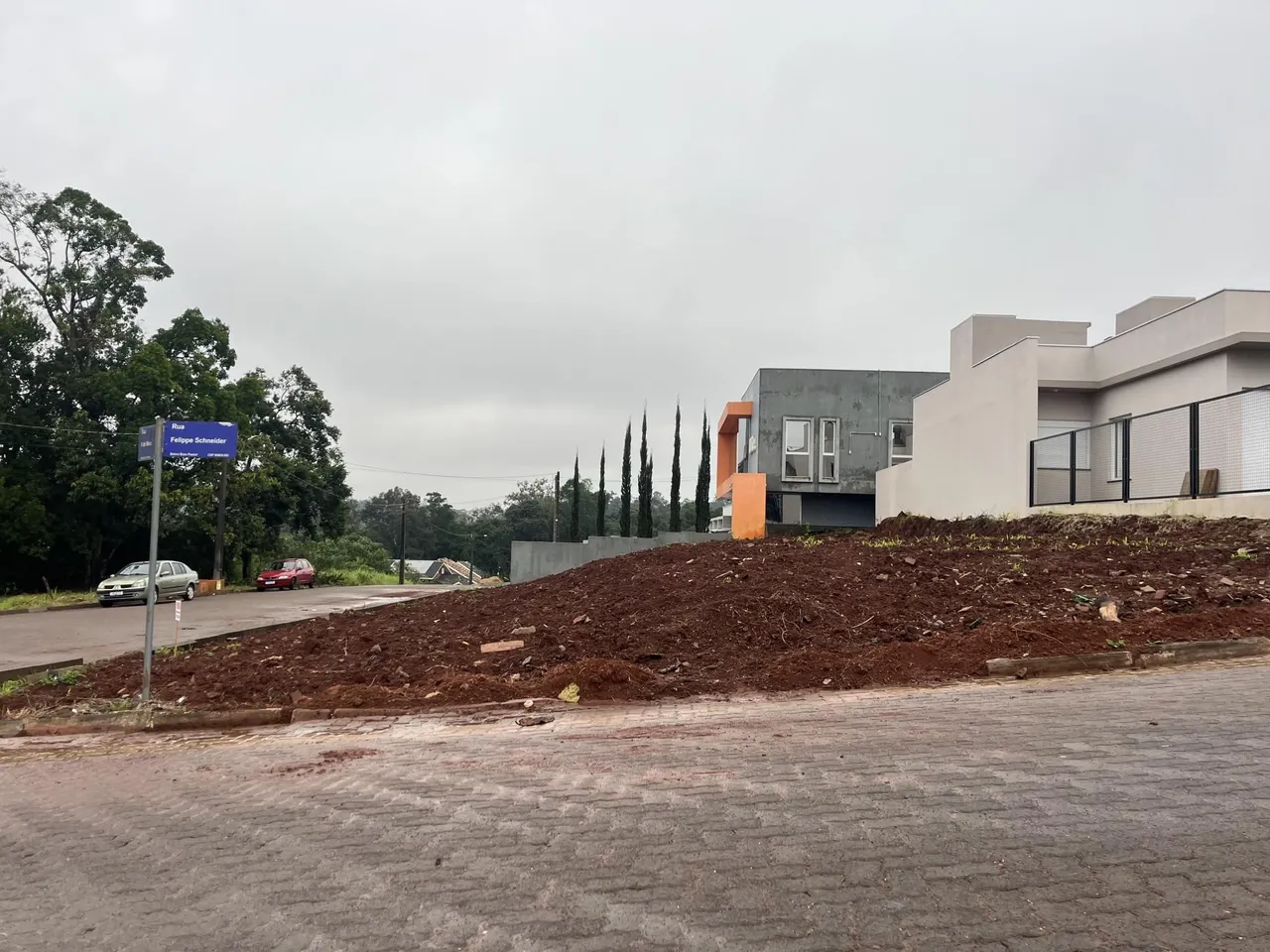 Fachada de uma residência moderna em Lajeado, Brasil, com área de terra revolvida em primeiro plano.