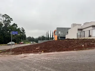 Fachada de uma residência moderna em Lajeado, Brasil, com área de terra revolvida em primeiro plano.