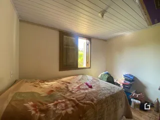 Quarto com cama e piso de madeira no interior da propriedade.