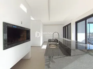 A sala de estar apresenta um ambiente moderno com lareira e grandes janelas.