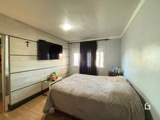 Quarto com cama e televisão na sala.