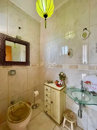 Interior de um banheiro com azulejos brancos e um espelho.