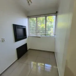 Foto interna de um cômodo com janela e piso claro.