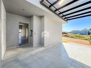 A foto mostra a fachada de uma área externa com piso de concreto.