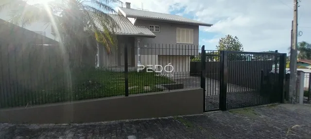 Fachada de uma residência com cerca e portão de ferro.