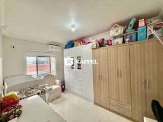 Quarto claro com cama e armários brancos em um ambiente bem iluminado.