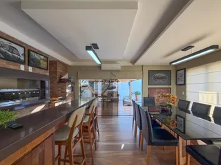 Vista de uma área comum com balcão e piso de madeira em um imóvel.
