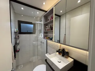 Banheiro moderno com box de vidro e revestimento cerâmico.