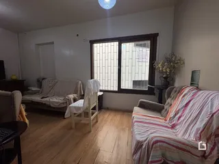 Sala de estar com piso de madeira e janela no interior da residência.