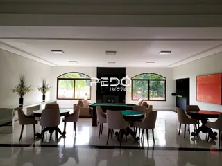 Sala de estar com piso de cerâmica e grandes janelas em um imóvel no Brasil.