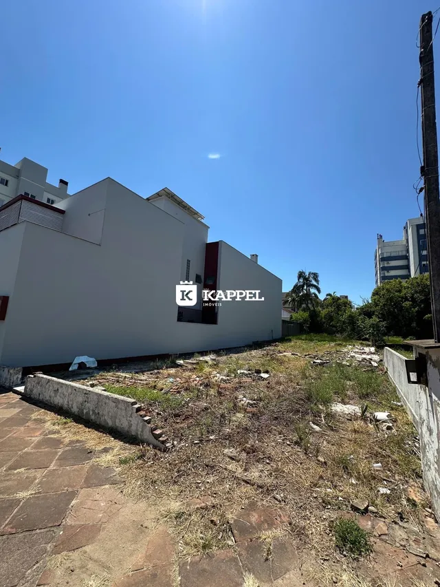 Fachada de uma residência branca com terreno baldio em Lajeado, Brasil.