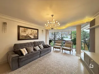 Sala de estar com sofá cinza e grande janela.