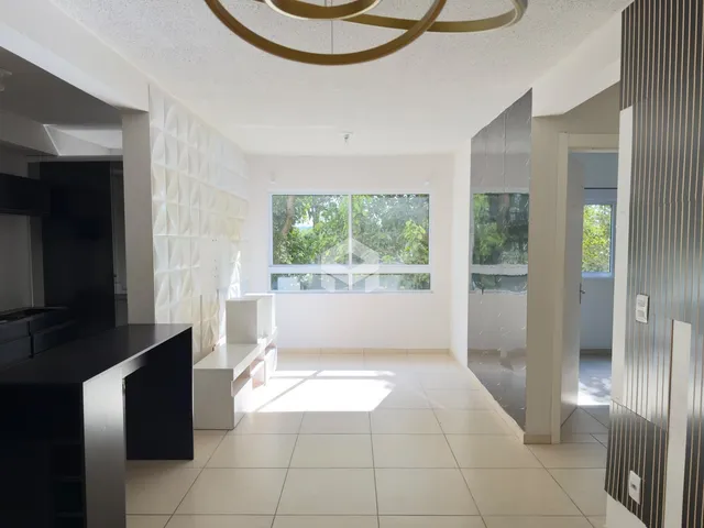 Sala de estar com piso claro e grande janela de luz.