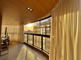 Sala de estar com grande janela oferecendo vista para a cidade.