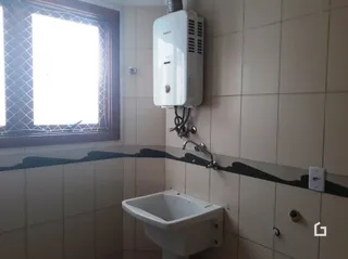 A foto mostra um banheiro com azulejos claros e um aquecedor de parede.