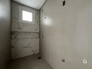 Vista de um corredor interno com revestimento de mármore nas paredes.