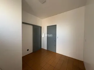 Hall de entrada com piso de cerâmica e portas em tom de cinza.
