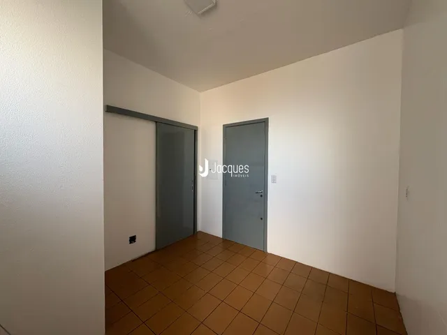 Hall de entrada com piso de cerâmica e portas em tom de cinza.