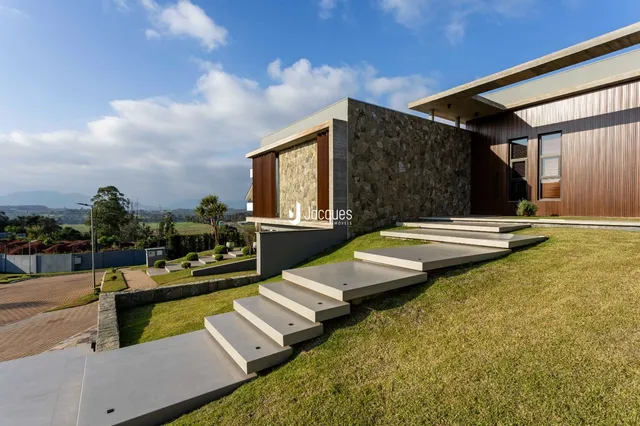 Fachada moderna de uma residência em Lajeado, Brasil, com jardim e escadaria.