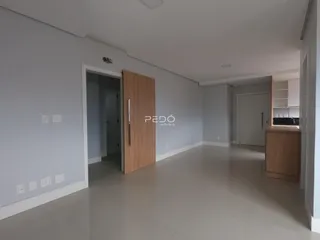 Um corredor interno de uma residência moderna com paredes cinzas e piso claro.
