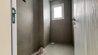 Hall de entrada com paredes cinzas e uma janela.
