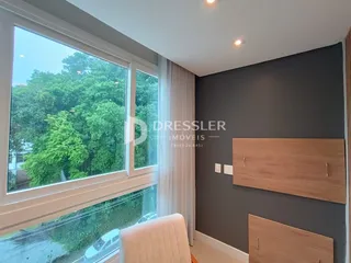 A sala de estar possui uma grande janela com vista para a vegetação externa.