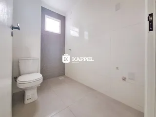 Foto de um banheiro com vaso sanitário e paredes brancas.