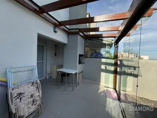 Vista de uma área externa com piso de cerâmica e estrutura de madeira em Lajeado.