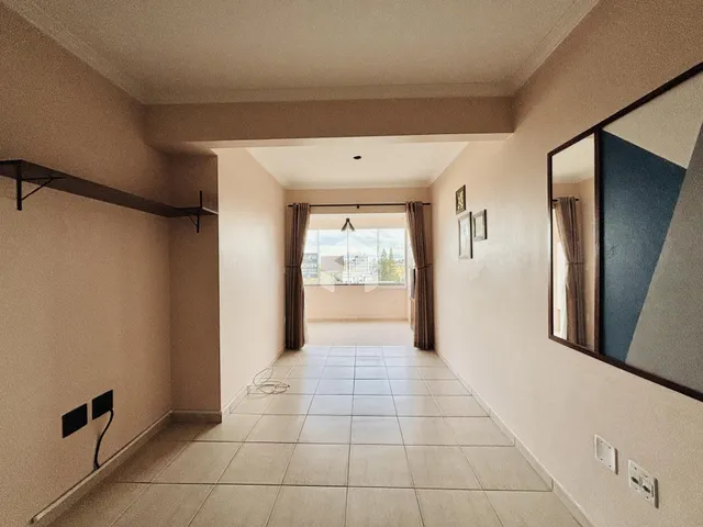 Hall da casa com piso de cerâmica e paredes claras.