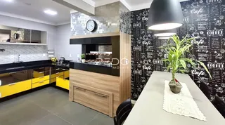 Foto de uma cozinha moderna com armários amarelos e bancadas escuras.