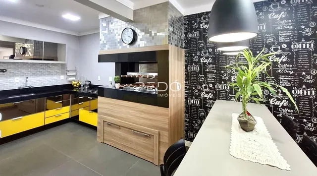 Foto de uma cozinha moderna com armários amarelos e bancadas escuras.
