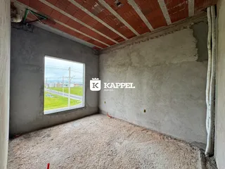 Foto de um cômodo interno com paredes de concreto aparente e teto de madeira.