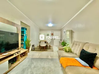 Sala de estar com sofá e televisão em um apartamento.