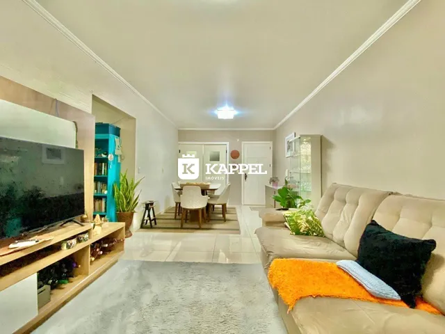 Sala de estar com sofá e televisão em um apartamento.
