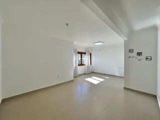 Hall de entrada de um ambiente interno com piso claro.