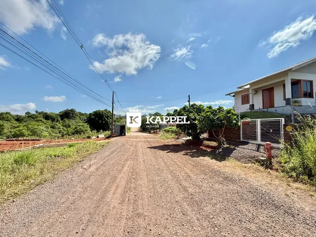 Vista da fachada de uma residência em Lajeado, Brasil, com uma estrada de terra no primeiro plano.