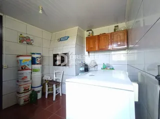 Interior de uma cozinha com revestimento cerâmico branco e armários de madeira.