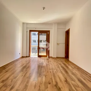 Ambiente interno com piso de madeira clara e paredes brancas.