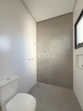 Foto de um ambiente interno com paredes brancas e revestimento cinza.