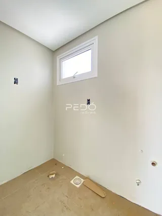 Uma parede branca com uma janela emoldurada em um ambiente interno.