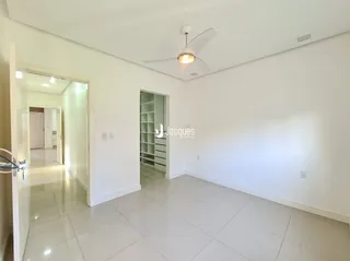 Hall de entrada com piso de cerâmica e paredes brancas.