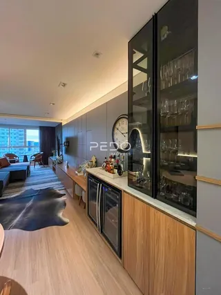 Sala de estar com piso de madeira e armários modernos.