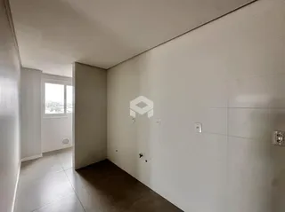 Corredor interno de uma residência com paredes brancas e piso claro.