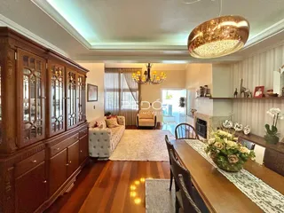 Sala de estar com piso de madeira e móveis de madeira escura.