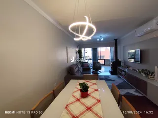 Sala de estar com sofá e televisão em um apartamento.