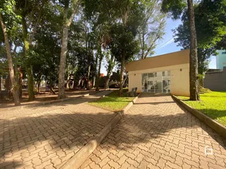 Vista da fachada de uma residência em Lajeado, Brasil, com jardim e calçada de tijolos.