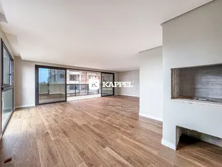 Sala ampla com piso de madeira e portas de vidro que dão para a vista urbana.