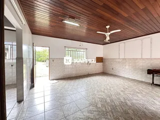 Sala ampla com piso de cerâmica e forro de madeira visível.