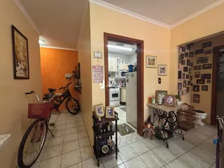 Hall de entrada com paredes em tons quentes e piso de cerâmica.
